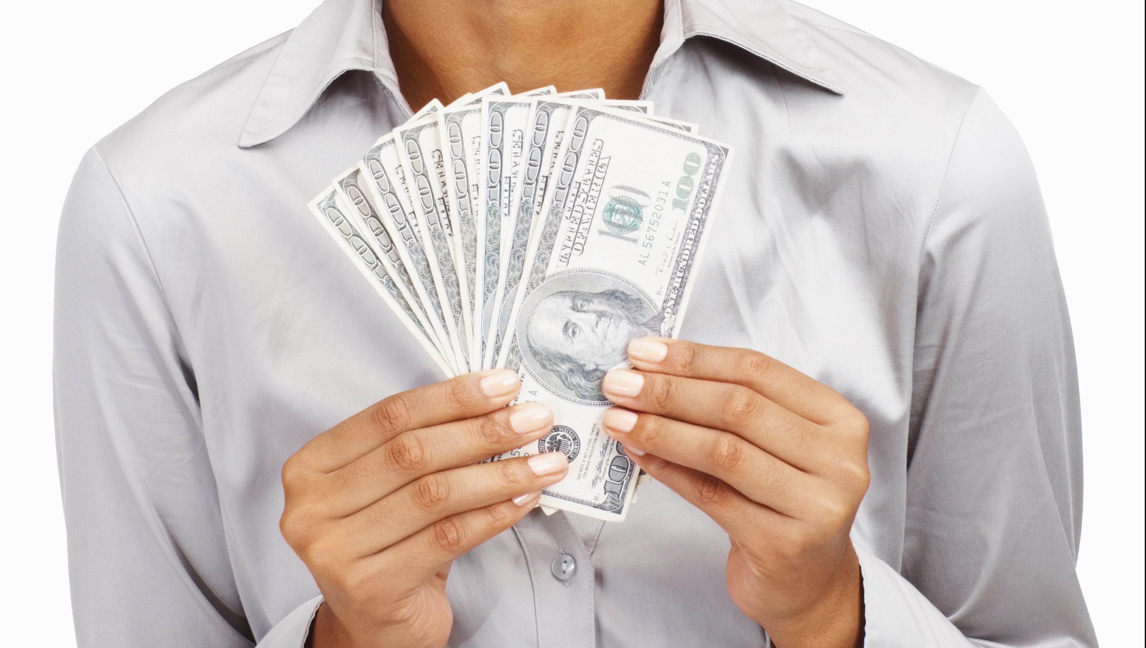 Happy young business woman holding currency notes against white