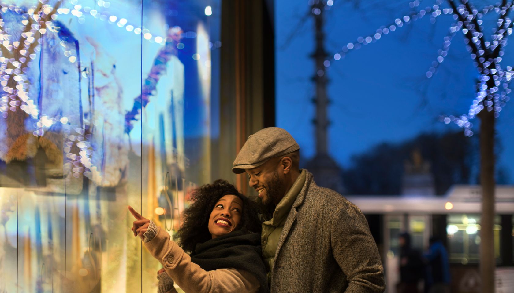 Couple window shopping in city at night, New York, USA
