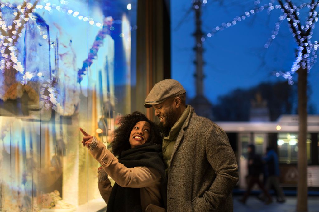 Couple window shopping in city at night, New York, USA