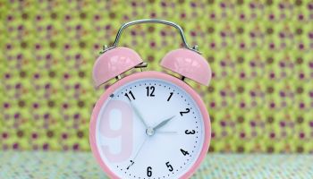 pink alarm clock in vintage background