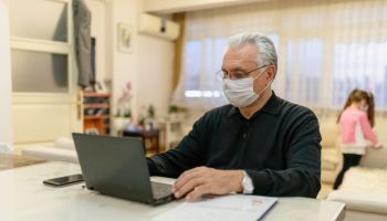 senior man working on laptop at home